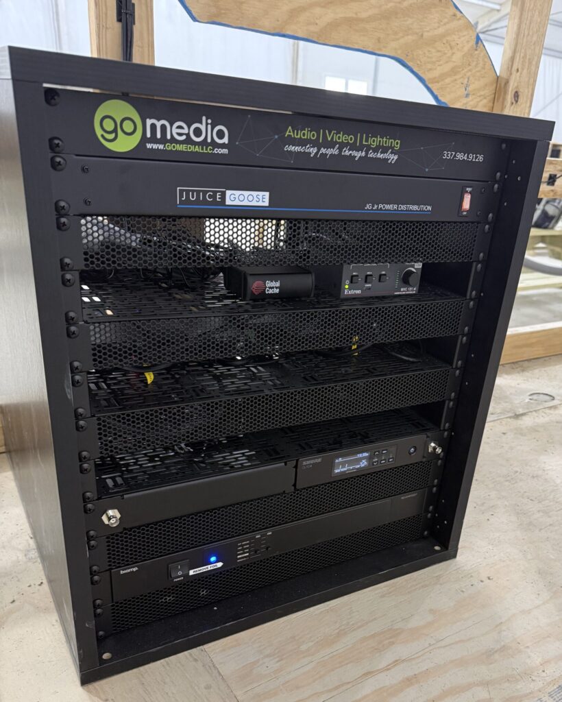 Commercial AV equipment rack with control processors, audio DSP, and network switches built by Go Media
